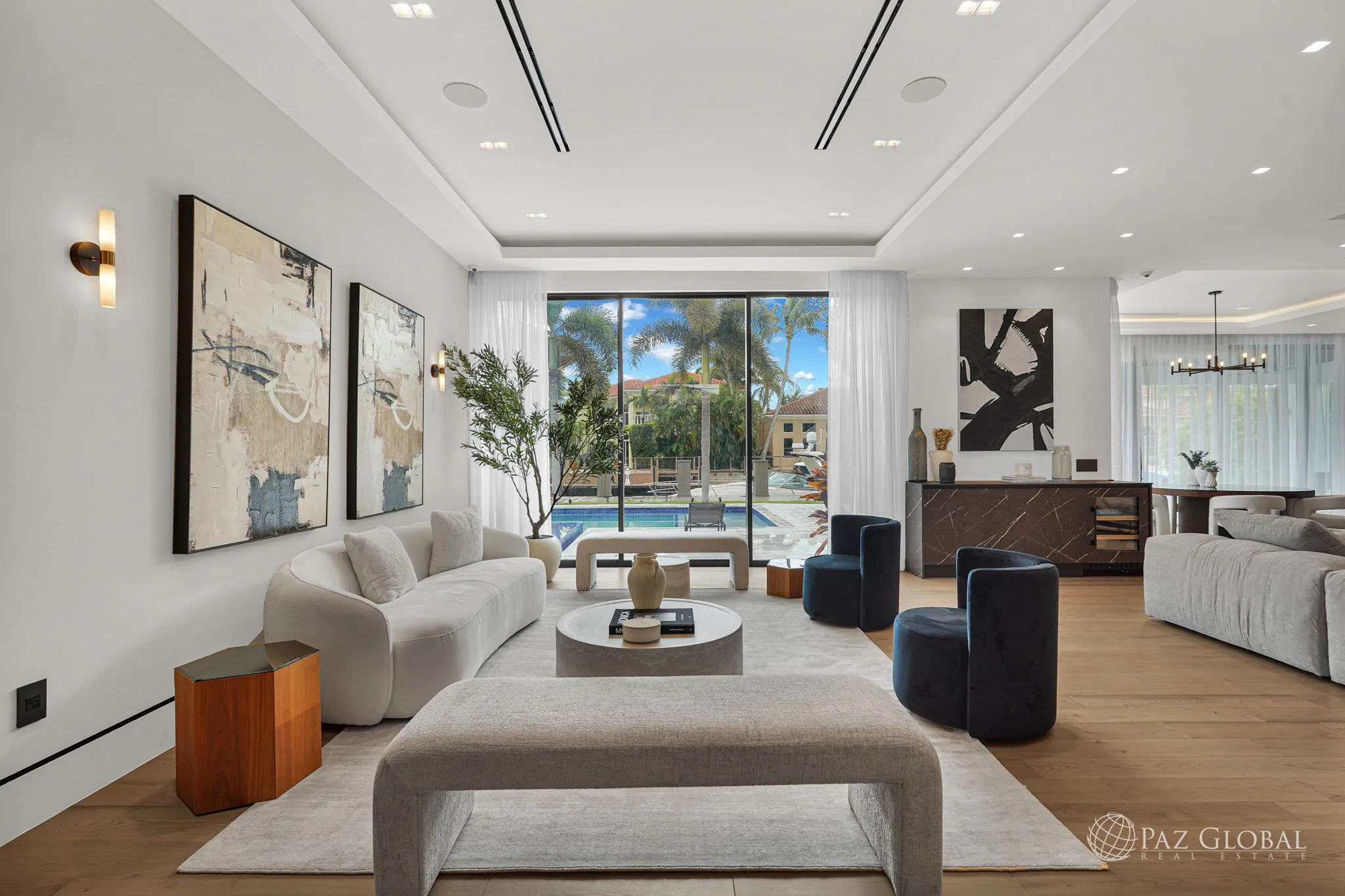 Living room with sliding glass doors open to the pool and water